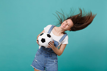 Happy young woman football fan with fluttering hair cheer up support favorite team with soccer ball...