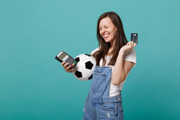 Overjoyed pretty young woman football fan support favorite team with soccer ball, wireless modern...