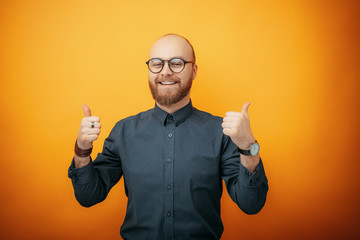 Handsome business man wearing glasses over isolated background success sign doing positive gesture...