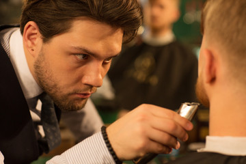Close up of a professional barber concentrating trimming beard of his male client copyspace profession job occupation styling barbering trimmer clipper barbershop beauty fashion wellness traditional.