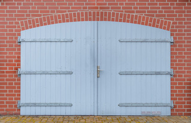blaues Garagentor an roter Klinkerwand