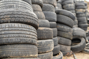 Old worn out tires on an abandoned trash dump. Garbage heap ready for disposal.