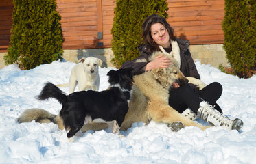 Beautiful Smiling Woman Playing with her Dogs Outdoor in the  Winter.Owner and Dogs Happy Together 