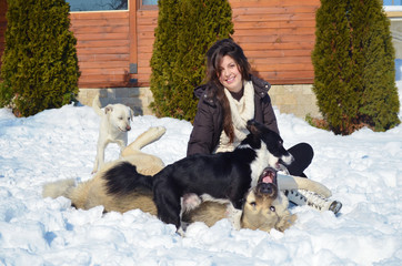 Beautiful Smiling Woman Playing with her Dogs Outdoor in the  Winter.Owner and Dogs Happy Together 