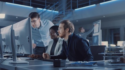 Electronics Development Engineer Working on Computer, Talks with Project Manager, Another Specialist Joins Discussion. Team of Professionals Use CAD Software for the Modern Engineering Design. 