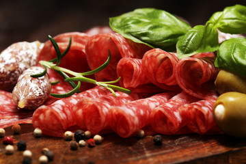 thinly sliced salami on a wooden texture on the background.