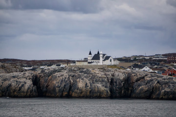 Homes in a little town on the rocky Atlantic Ocean Coast during a cloudy sunset. Taken in...