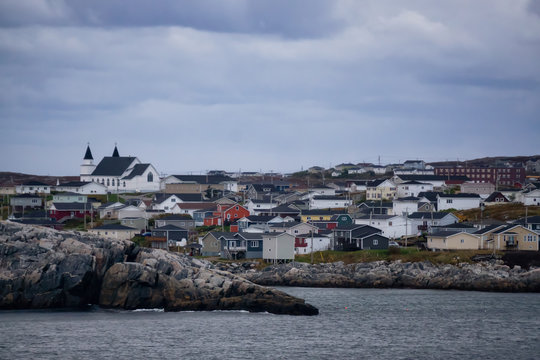 Homes in a little town on the rocky Atlantic Ocean Coast during a cloudy sunset. Taken in Channel-Port aux Basques, Newfoundland, Canada.