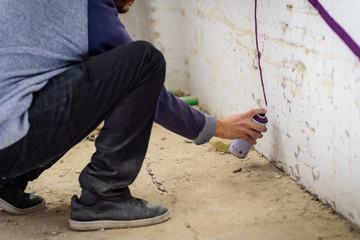 Joven con pintura en aerosol para pintar en pared 04