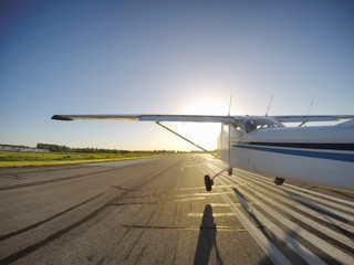 Small airplane taking off from the Runway at an airport during a vibrant sunny sunset. Taken in Pitt Meadows, Greater Vancouver, BC, Canada.