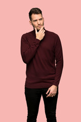 Man with turtleneck sweater thinking over pink background