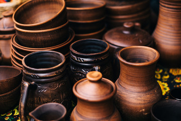 A lot of pottery at the fair. Ceramic national Russian dishes made. Burnt black ceramics. Burnt clay pots and plates, dishes