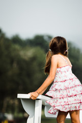 young girl Standing In A Field with A White Dress..