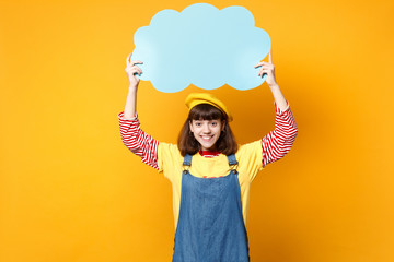 Smiling girl teenager in french beret, denim sundress hold blue empty blank Say cloud, speech...