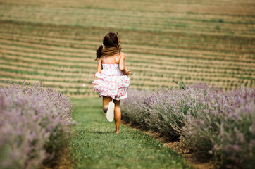 girl in white dress running on a field of lavender
