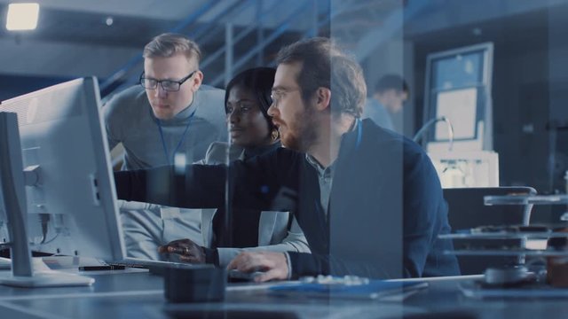 Two Electronics Development Engineers Working on Computers, Talk with Project Manager. Team of Professionals Use CAD Software for the Modern Industrial Engineering Design. Slow Motion Shot