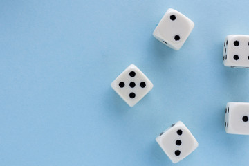 White gaming dices on light blue background. victory chance, lucky. Flat lay, place for text. Top view. Close-up. Concept gamble. spectacular pastel