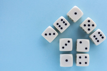 White gaming dices on light blue background. victory chance, lucky. Flat lay, place for text. Top view. Close-up. Concept gamble. spectacular pastel