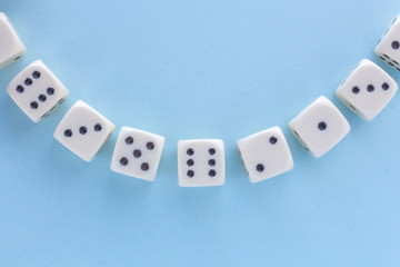 White gaming dices on light blue background. victory chance, lucky. Flat lay, place for text. Top view. Close-up. Concept gamble. spectacular pastel