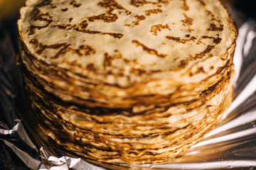 A stack of pancakes for pancake week on the street. people hand out pancakes at the festival