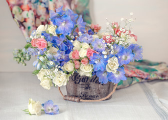 Close-up  composition with a with different flowers.Delphiniums and roses .Many beautiful fresh flowers on a table. Pastel colors.