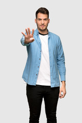 Handsome man happy and counting four with fingers over grey background