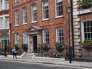 Fototapeta na wymiar London building facades near Mayfair, with floral window boxes