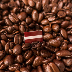 a Latvia flag placed over roasted coffee beans