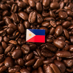 a philippines flag placed over roasted coffee beans