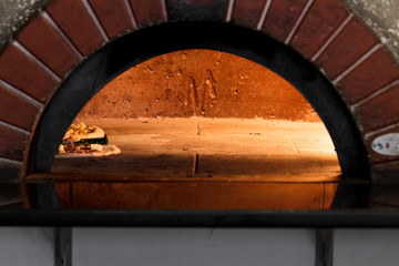 Baking pizza at hot oven.