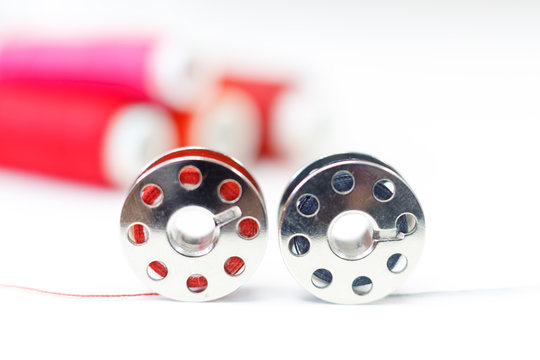 sewing bobbin and row of spools of thread