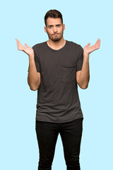 Man with black shirt having doubts while raising hands over blue background