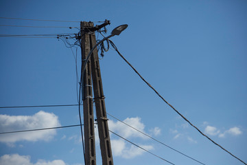 Strommast aus Beton mit Strassenlaterne und Telekomleitungen