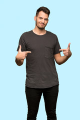 Man with black shirt proud and self-satisfied over blue background