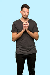 Man with black shirt scheming something over blue background