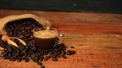 Coffee cup with Coffee beans, burlap sack and with cinnamon sticks