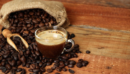 Coffee cup with Coffee beans, burlap sack and with cinnamon sticks