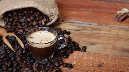 Coffee cup with Coffee beans, burlap sack and with cinnamon sticks