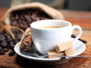 Coffee cup with Coffee beans, burlap sack and with cinnamon sticks
