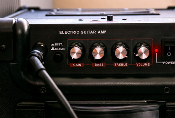 Guitar amplifier with dials and controls for volume, gain, bass, treble.