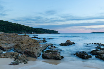 Long exposure view of beach shore with a lot of rocks.