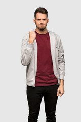 Fototapeta premium Man with sweatshirt with angry gesture over grey background