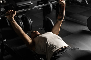 Bodybuilding. Bearded man lying doing bench press at gym with barbell concentrated