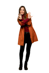 Full-length shot of Young woman with coat counting ten with fingers on isolated white background
