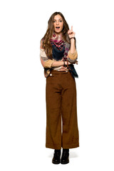 Full-length shot of Young hippie woman thinking an idea pointing the finger up on isolated white background