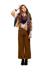 Full-length shot of Young hippie woman having doubts while scratching head on isolated white background