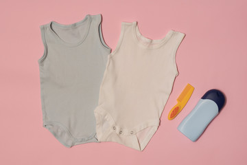 Blue and white baby bodysuit on a pink background. Accessories. Fashion concept