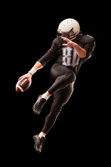 Fototapeta na wymiar American football player in a jump with a ball on a black background