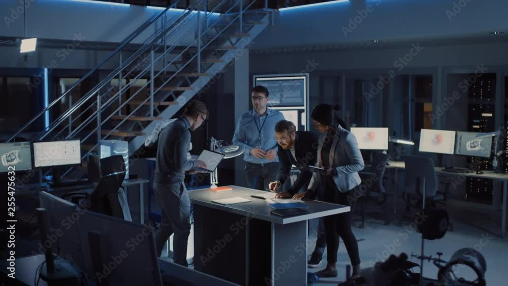 Leinwandbilder Diverse Team of Electronics Development Engineers Gather at the Desk Working with Documents, Solving Project Problems Late at Night. Specialists Working on Ultra Modern Industrial Design. Slow Motion