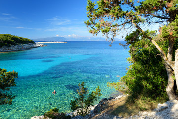 Scenic view of Emplisi Beach, picturesque stony beach in a secluded bay, with clear waters popular for snorkelling. Small pebble beach near Fiscardo town of Kefalonia, Greece.